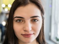 smiling woman having brow color added to her eyebrows